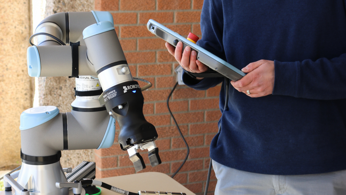 Robotics image featuring professor and robotic arm