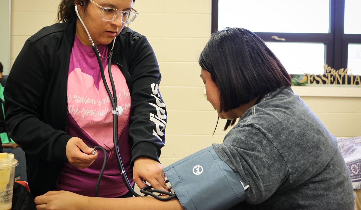 Students taking each others blood pressure