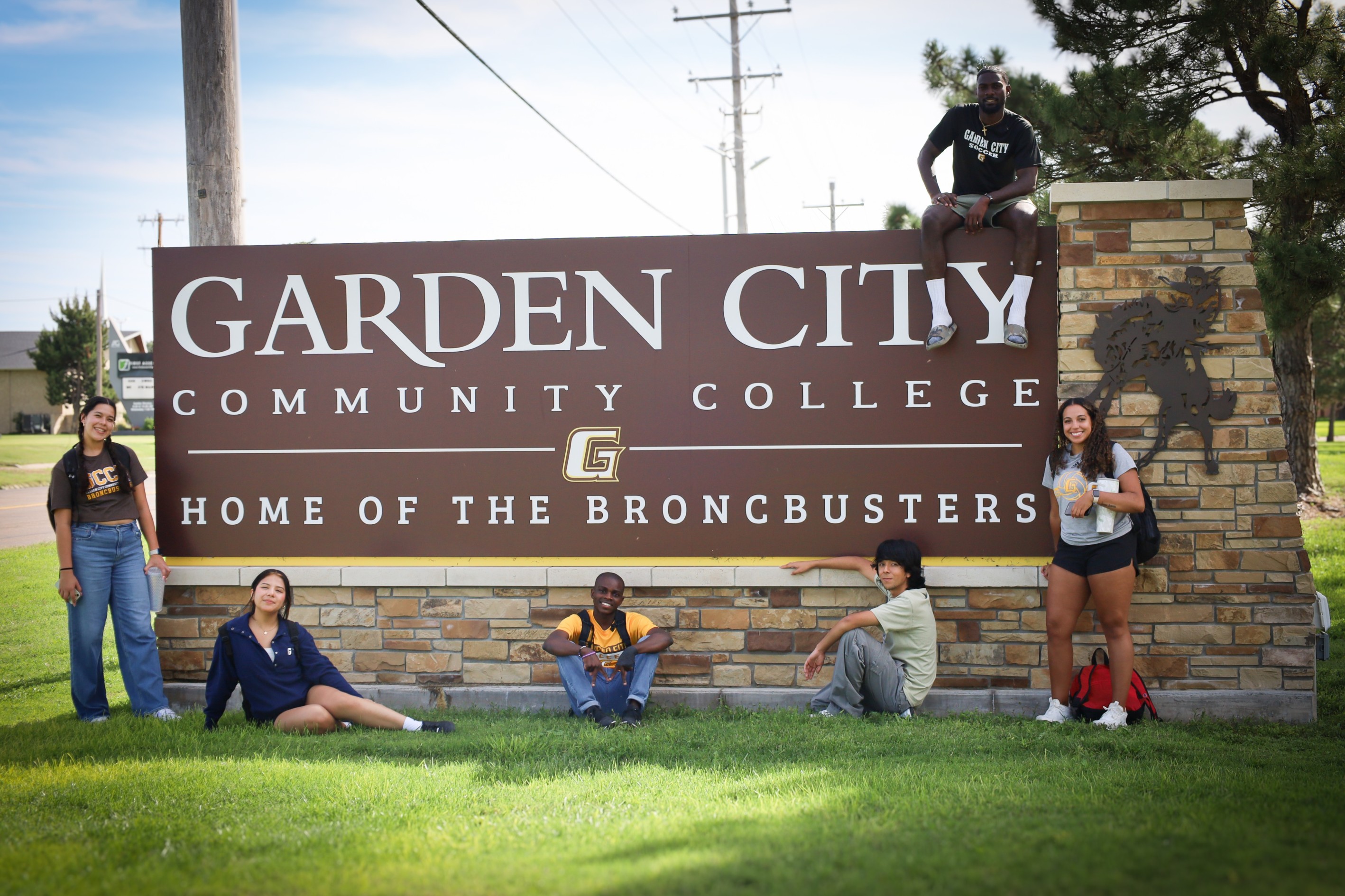 Group of college students gathered around the Garden City Community College entrance sign.