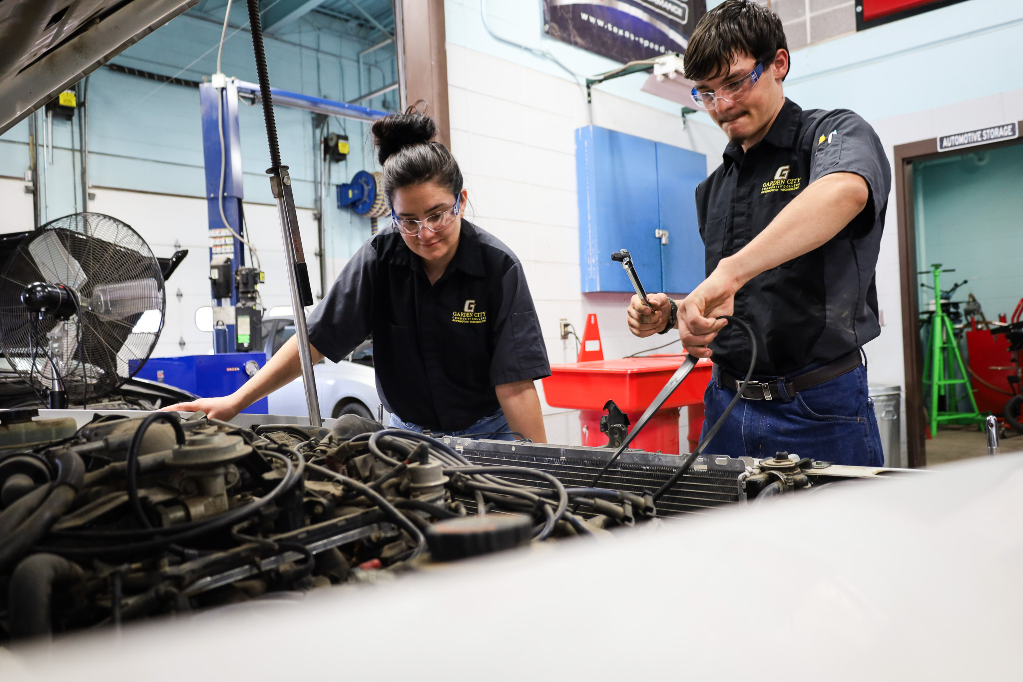 automotive students working on motor vehicle.