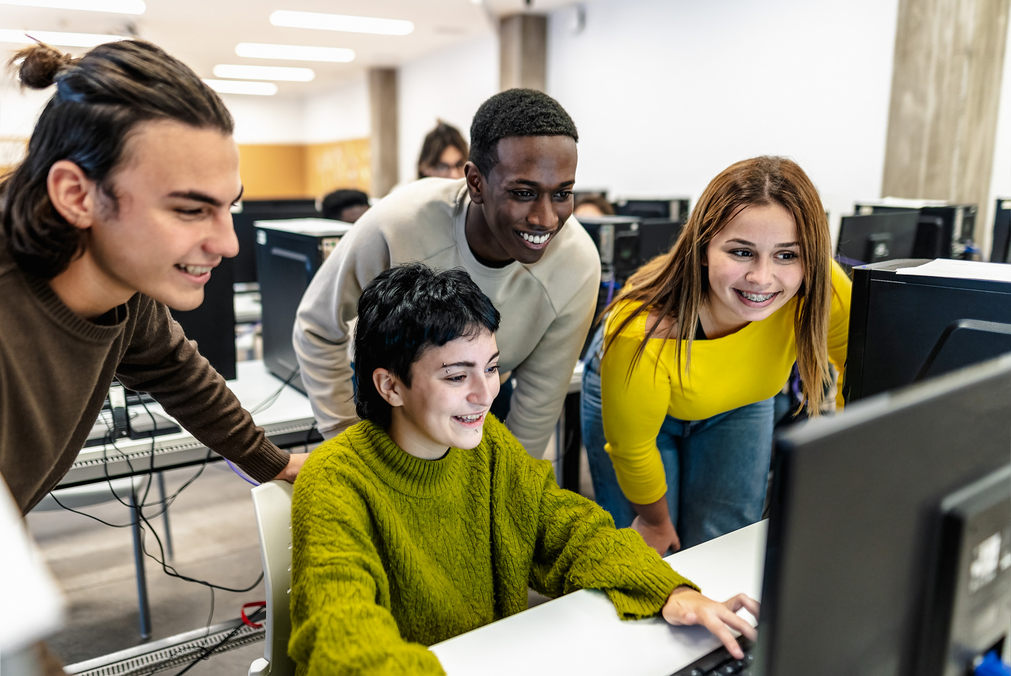 students in a computer lab collaborating.