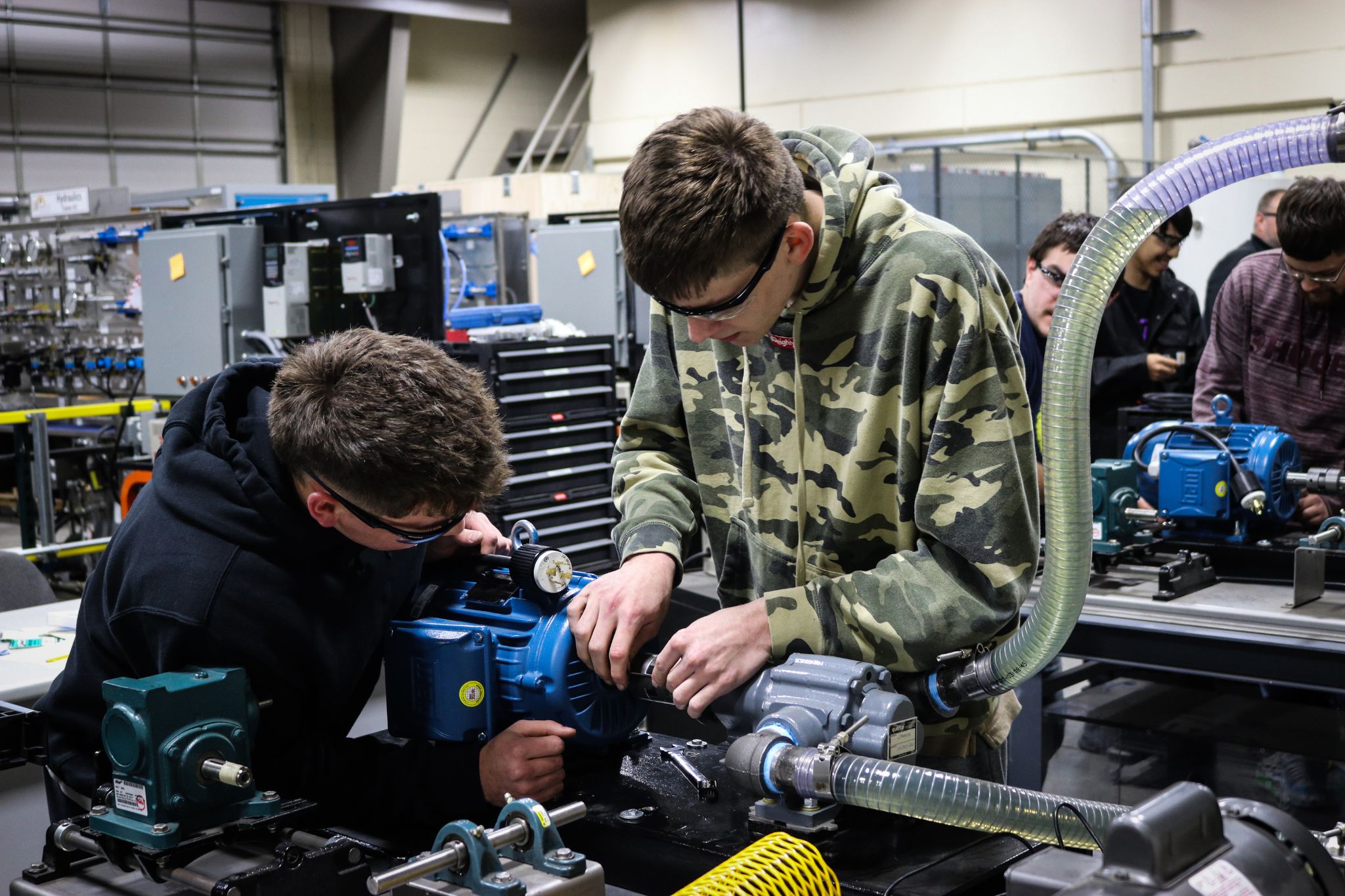 two students working on motor vehicle in lab