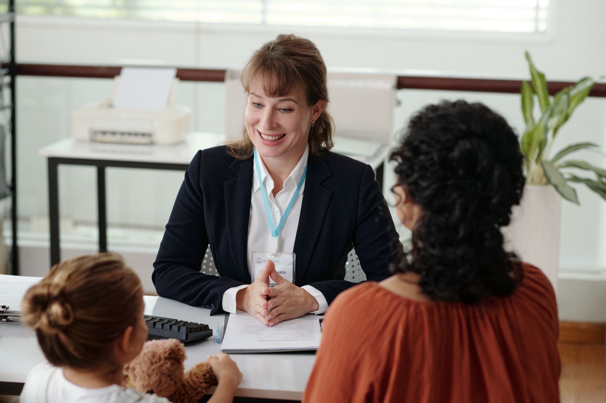 person sitting at desk assisting two people