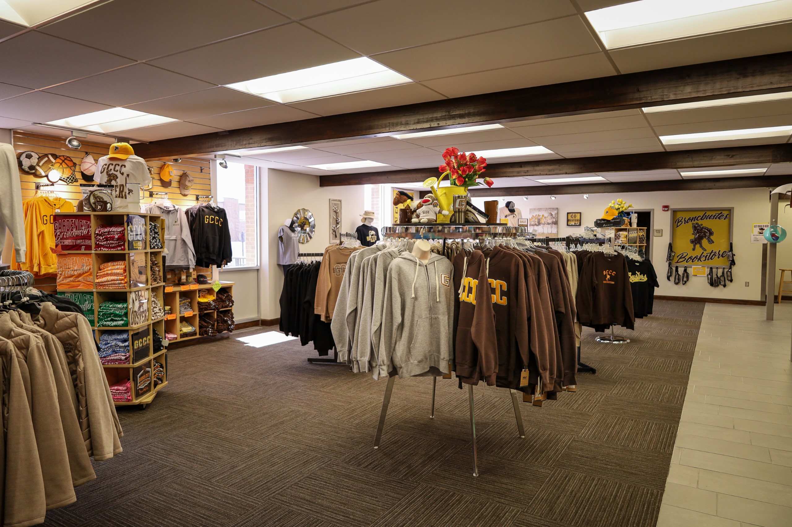 Generating response&nbsp; Copilot said:  Campus bookstore displaying college-branded apparel, gifts, and merchandise on clothing racks and shelves.